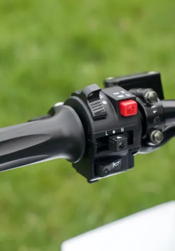 Zbliżenie na manetkę kierownicy z przyciskiem rozrusznika oraz innymi przełacznikami