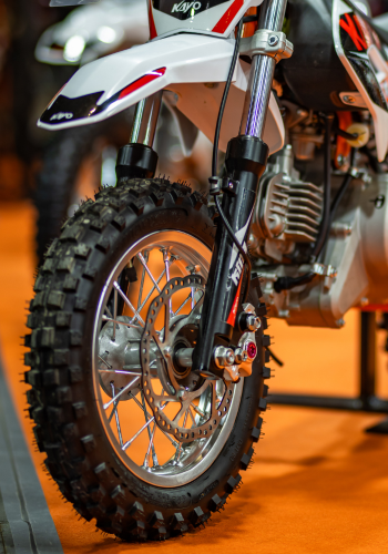 Zbliżenie na aluminiowe koło przednie KAYo 50 KMB. Na zdjęciu widoczna róenież tarcza hamulca oraz fragment zawieszenia przedniego.