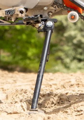 Rozłożona stopka motocykla KAYO 110 TSD w trakcie postoju - zbliżenie